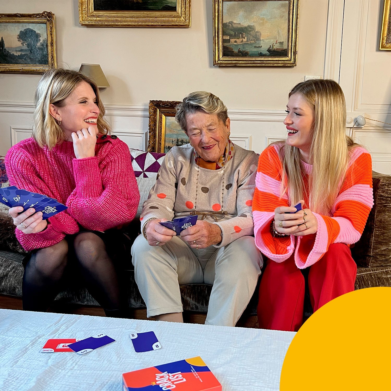Tre donne che giocano al gioco di carte Crack List con la loro famiglia